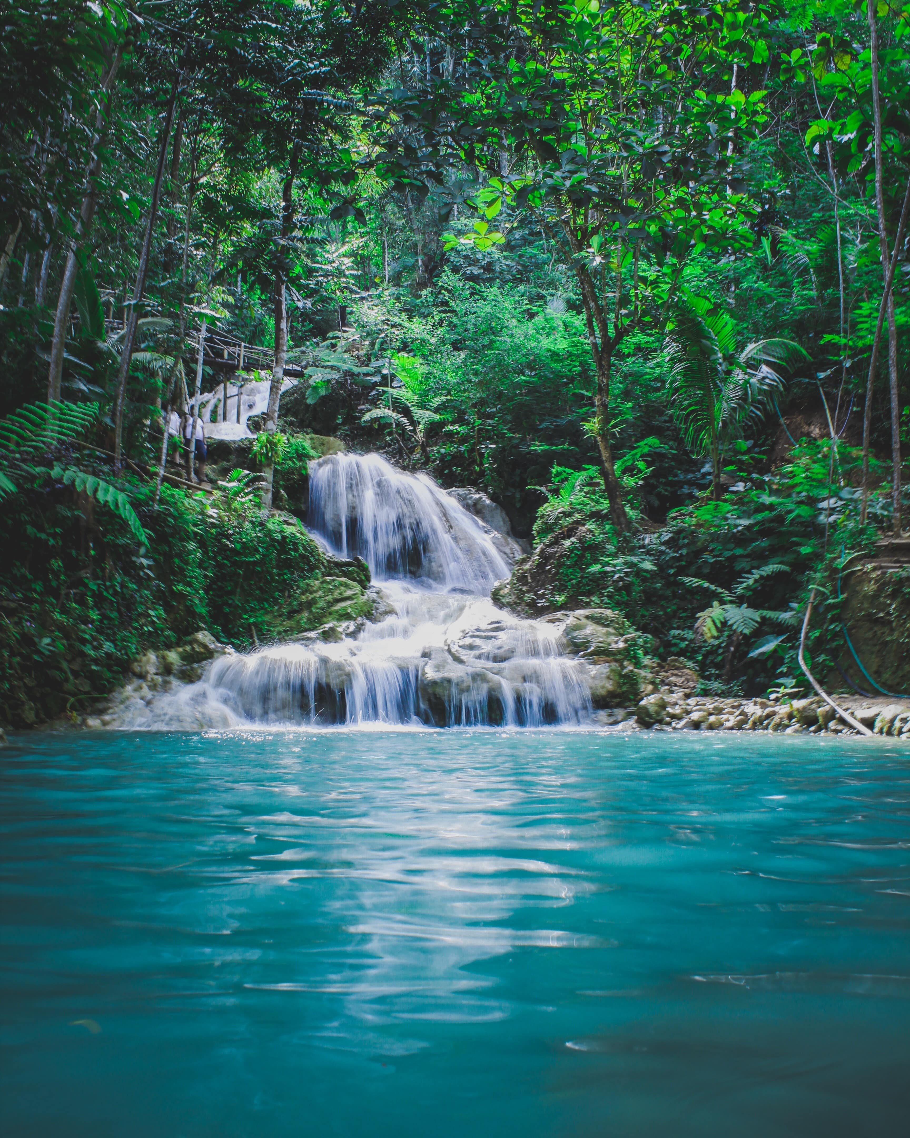 Witness nature's beauty as water cascades into a serene lagoon. Immerse yourself in tranquility with DREW TRAVEL.